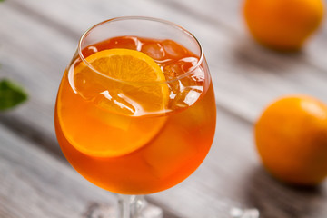 Orange drink in a wineglass. Ice and slice of orange. Aperol spritz with imported wine. Have fun at...