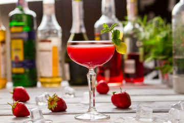 Red drink in a glass. Beverage decorated with mint. Clover club with sweet juice. Egg white and gin.