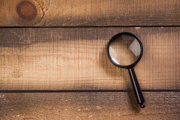 magnifying glass on the wooden background