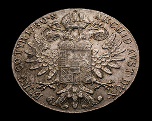 Old silver coin isolated on black
