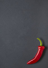 A red chilli pepper on a rustic slate background forming a cooking themed page border