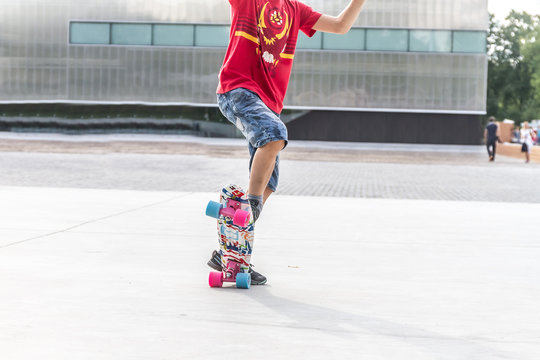 close up of boy's feet standing on modern short cruiser skateboa