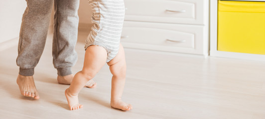 baby steps with the help of his mother