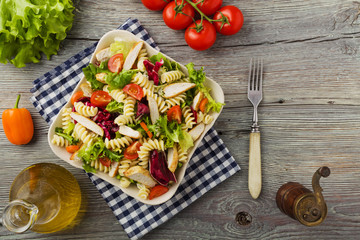 Noodle salad with green lettuce, tomatoes and roasted chicken.