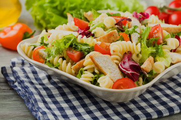 Noodle salad with green lettuce, tomatoes and roasted chicken.