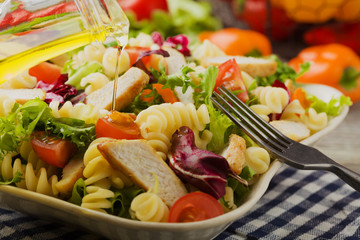 Noodle salad with green lettuce, tomatoes and roasted chicken.