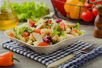 Noodle salad with green lettuce, tomatoes and roasted chicken.