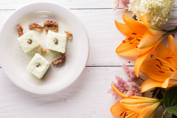 orange lily and candies on plate