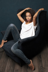 African woman sitting in blue armchair