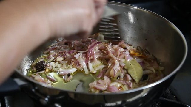Cooking and stirring chopped Onions in olive oil 