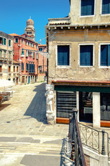 Fototapeta na wymiar Old houses on a street in central Venice in Italy