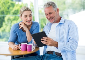 Smiling mature couple using digital tablet 