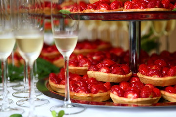wedding cake/ strawberry pastries on a plate with glasses of champagne