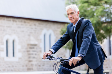 Fototapeta premium Successful businessman riding bicycle