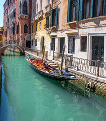 Fototapeta na wymiar Gondola, old buildings and bridge in central Venice