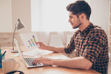 Side view of concentrated young man working with laptop and diag