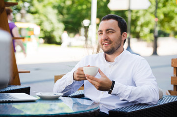 Confident successful businessman in suit enjoying a cup of coffee while having work break lunch in...