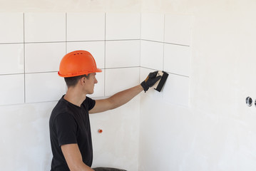 laying ceramic tiles on a wall