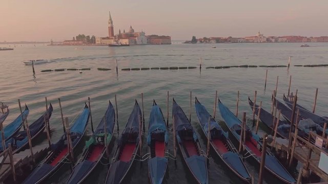 Drone aerial flying over parking gandolas with the bell tower of the Saint Giorgio Maggiore Church view.