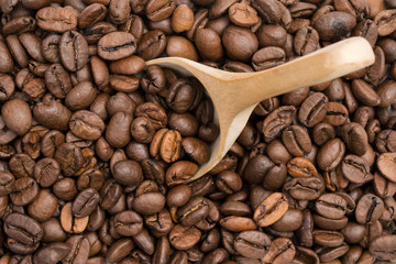 Coffee beans with wooden spoon seen from above