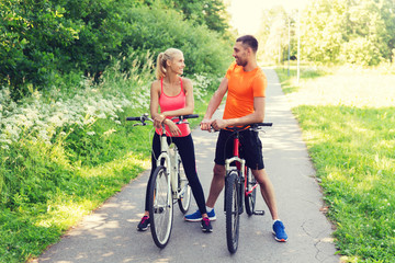 happy couple riding bicycle outdoors