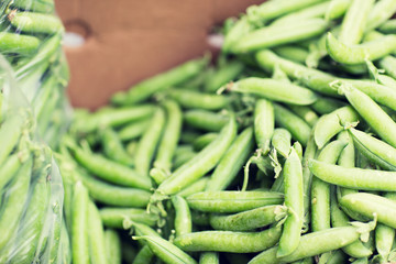 close up of green peas in box at street market