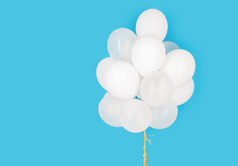 close up of white helium balloons over blue
