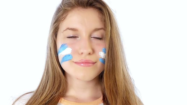Girl with Argentinian flag on her face smiling