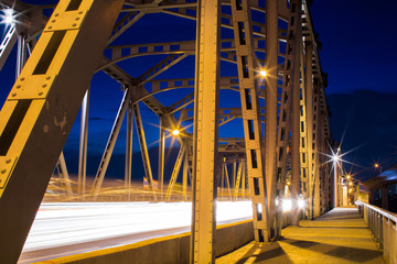 Iron bridge with car light trails in the night