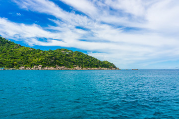 Sea with rock mountain blues sky background