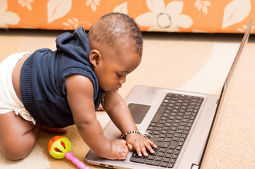 bébé sur un ordinateur portable dans la maison