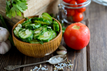 Fresh cucumber salad with fennel and garlic in bowl on wooden board