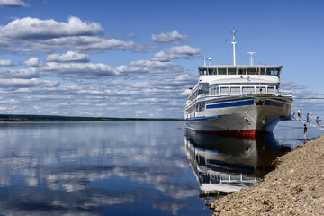 Fototapeta na wymiar Passenger boat moored to a river Lena bank
