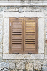 Old wooden window on the stone wall