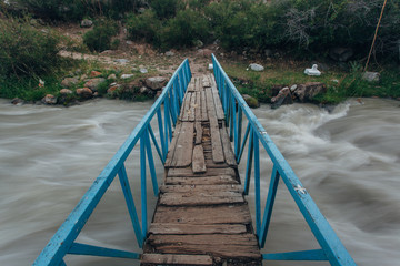 Fototapeta na wymiar The old bridge through a mountain stream
