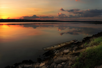 Fototapeta premium sunset on the river, fishing boat on the shore