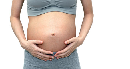 Close up of a cute pregnant belly. Isolated on white background