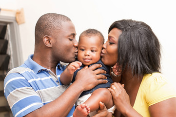 portrait  de couple heureux embrassant tendrement leur bébé 