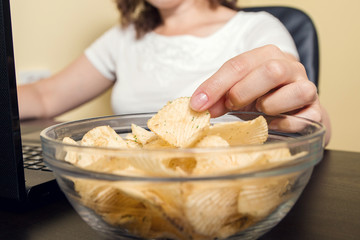 Close-up of a hand of a young women taking potato crisps 