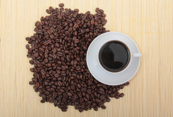 Coffee beans and a white cup on table