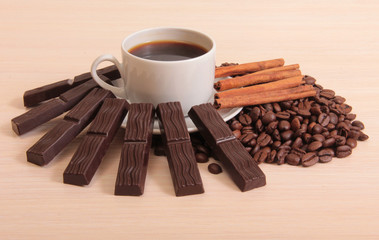Coffee cup and chocolate on a wood background