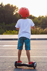 Boy stands on the black gyro scooter outdoors