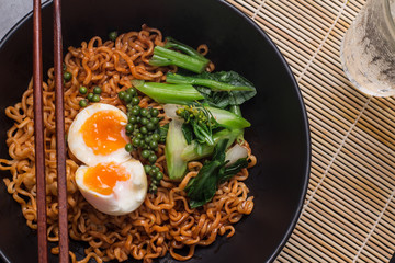 noodles in black bowl garnished on kitchen table