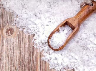 Sea salt with wooden scoop on vintage  wooden surface
