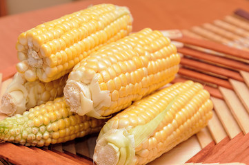 Fresh corn on cobs rustic wooden table, closeup