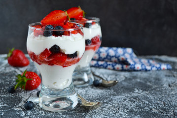 dessert with whipped cream, strawberries, blueberries in a glass