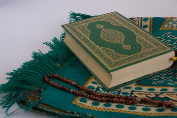 Koran on white background with rosary