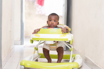 b&eacute;b&eacute; surpris assis dans une poussette dans la maison