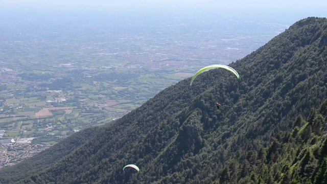 Paragliding flying. In the background the Venetian plain - Monte Grappa, Italy 