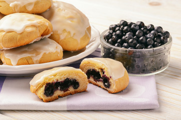 Blueberry filled yeast buns on white table.